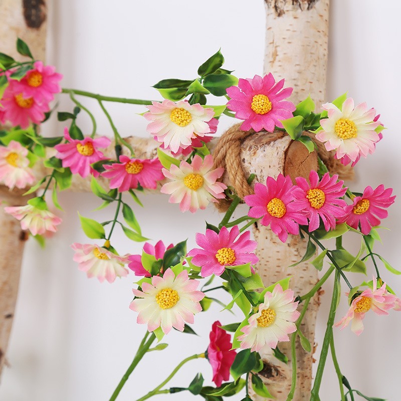 デイジーの花藤の造花の藤条のヒマワリのエアコンのパイプをシミュレーションして室内の背景の壁のショーウインドーの装飾を巻いて遮ります。|undefined