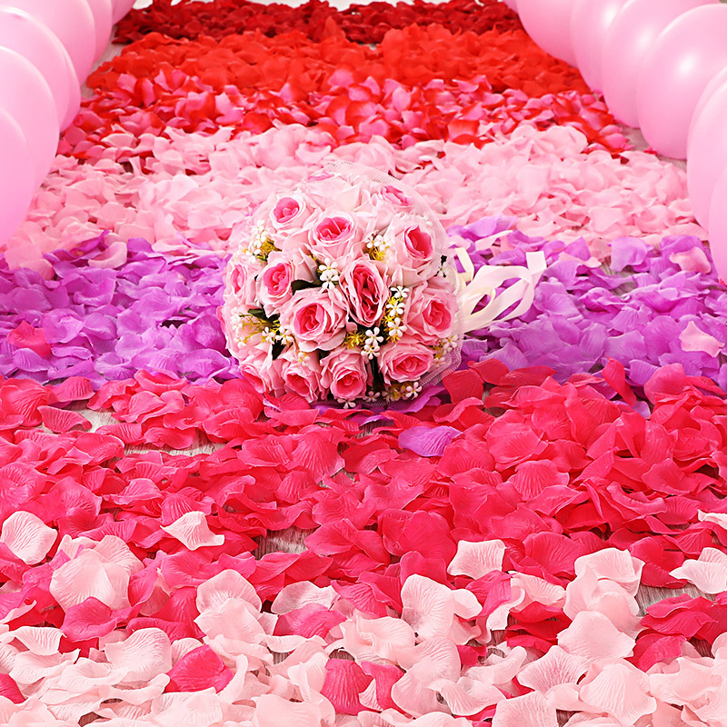 バラの花びらのバレンタインデーの装飾をシミュレーションして結婚部屋のベッドの上で手を振って花のプロポーズの贈り物の告白のロマンチックな手を振って花を投げます。|undefined