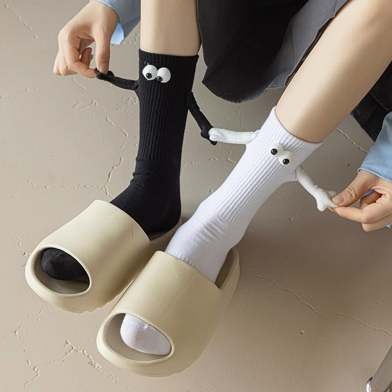 手をつないで靴下をつないでいるカップルは磁気的に手をつないでかわいい足をつないでいる靴下の夏の薄い綿は自動的に鉄の石の中の筒を貼ります。|undefined