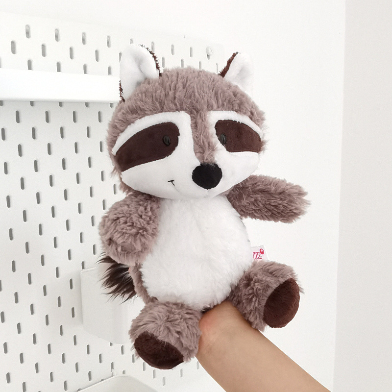 アライグマのぬいぐるみが可愛いです。熊のぬいぐるみを抱いています。|undefined