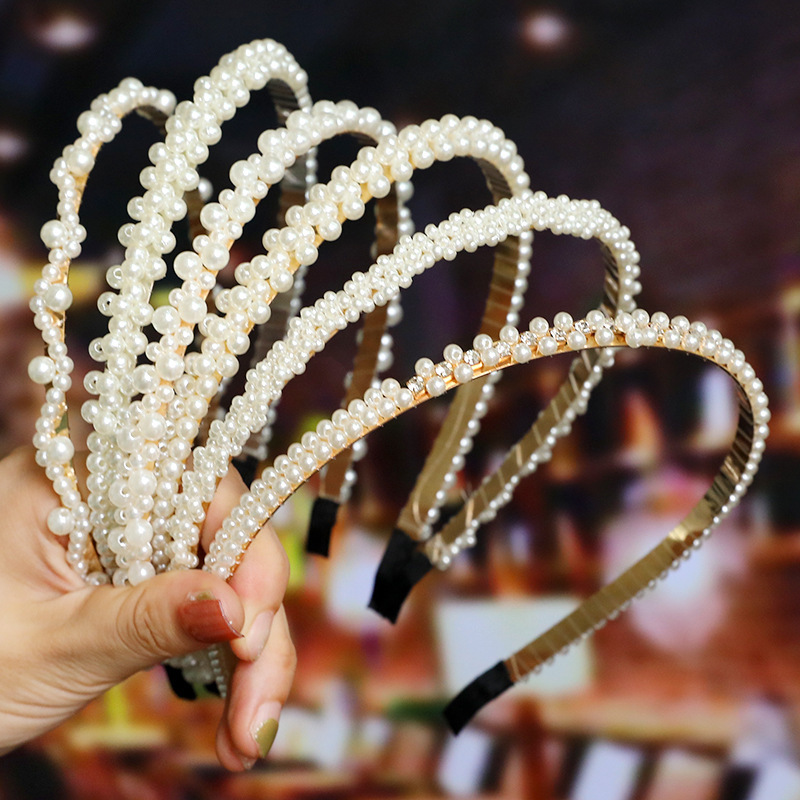 花嫁の髪飾りの女性が手作りで真珠のカチューシャを結びます。|undefined