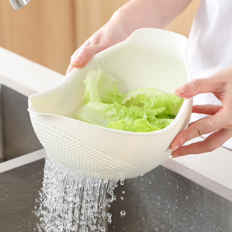 米を研ぐかごの家庭用の米を研ぐふるいで米を洗うたらいの台所の水たまりのかごを洗って野菜を洗って果物のプラスチックのたらいを洗います。|undefined