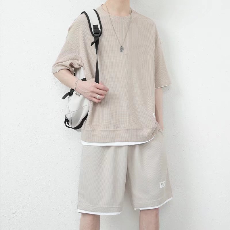 A stylish and trendy summer men's set featuring a waffle casual suit with a cool ice silk short-sleeved T-shirt paired with sporty shorts.