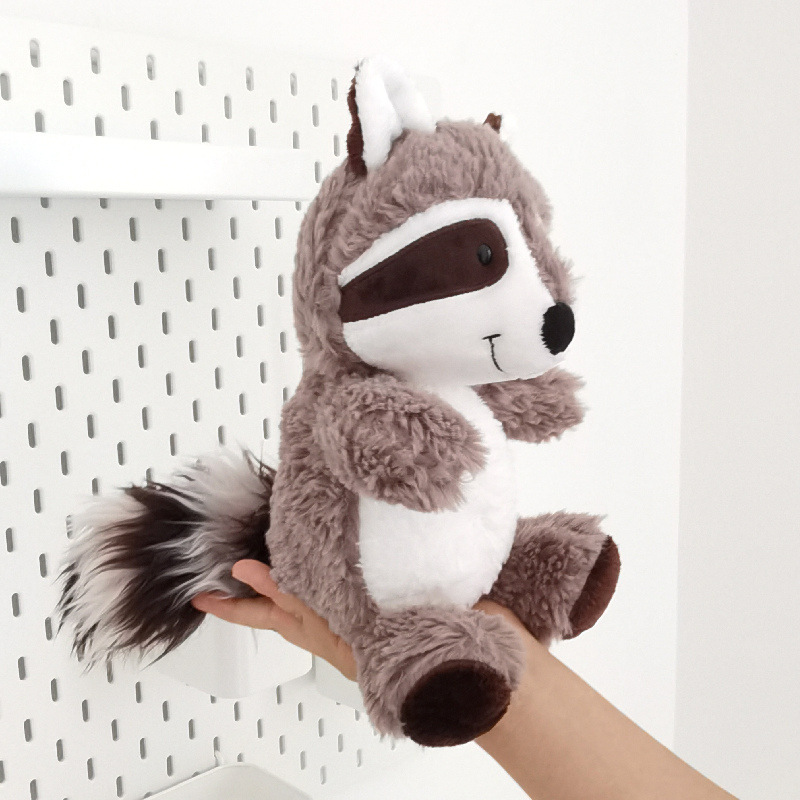 アライグマのぬいぐるみが可愛いです。熊のぬいぐるみを抱いています。|undefined